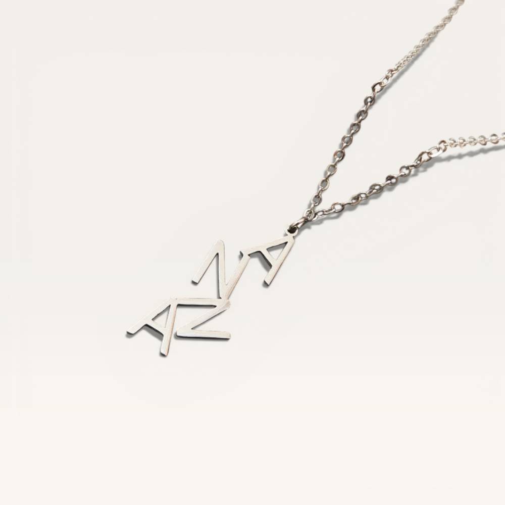 Silver necklace with 'AZA' pendant on a white background
