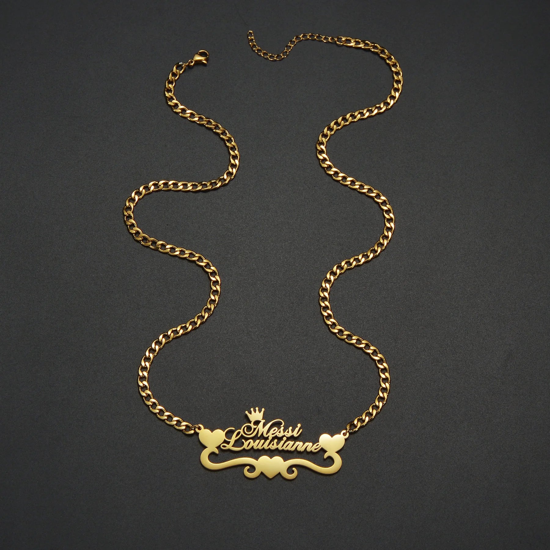 Gold chain necklace with a decorative clasp on a dark background