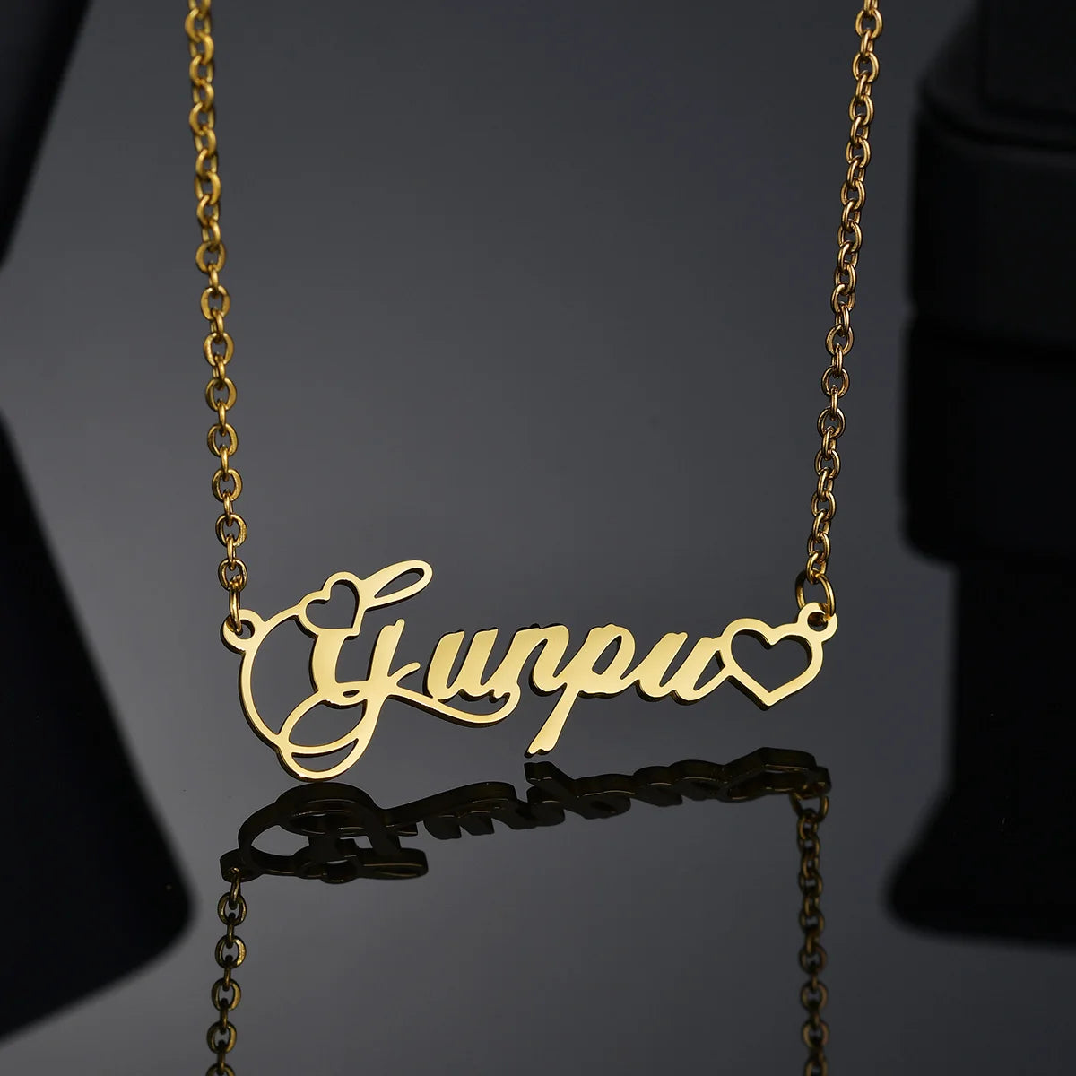 Gold necklace with 'Gurpreet' pendant on a dark background