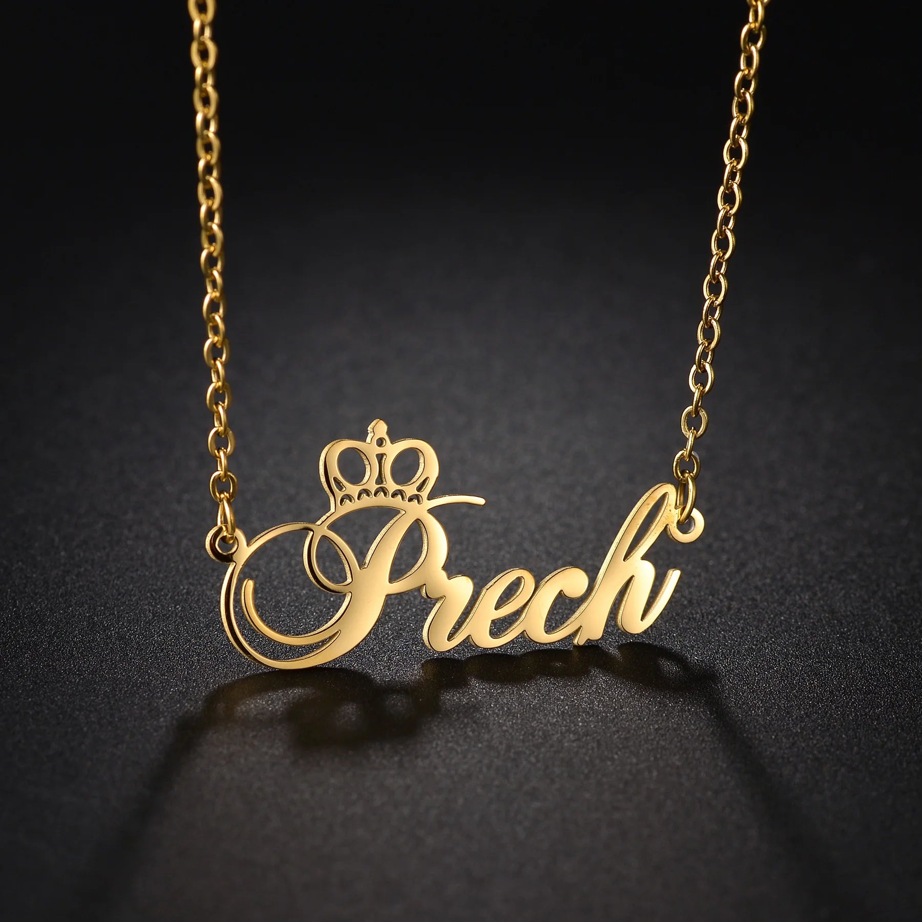 Gold necklace with 'Prech' pendant on a dark background