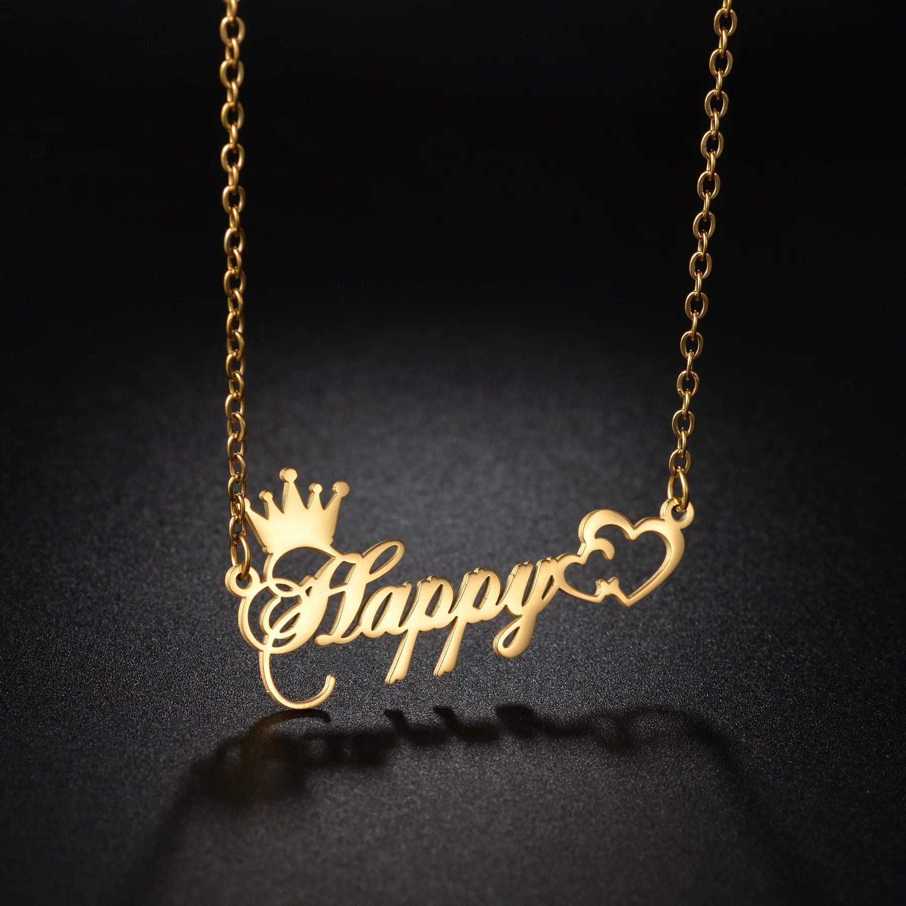Gold necklace with 'Happy' and crown design on a black background