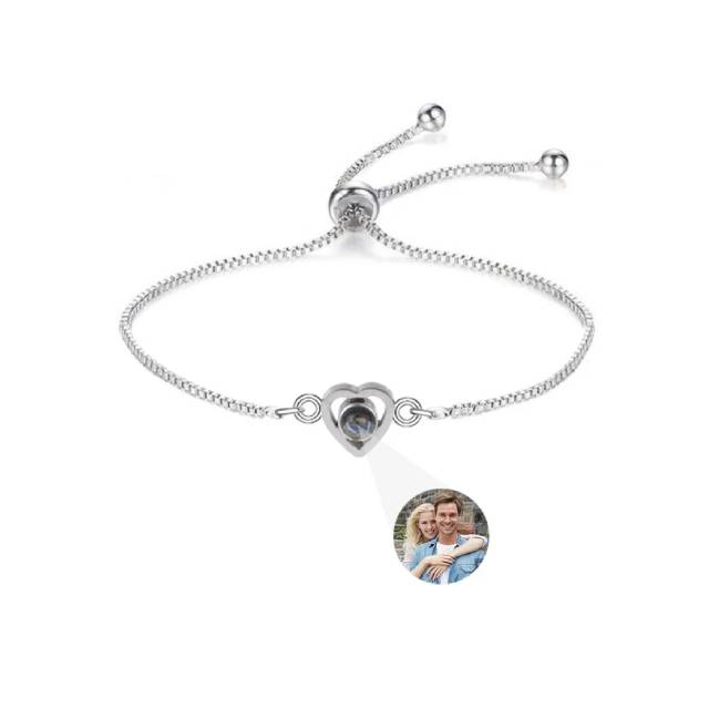 Silver bracelet with heart-shaped clasp featuring a photo of a couple on a white background