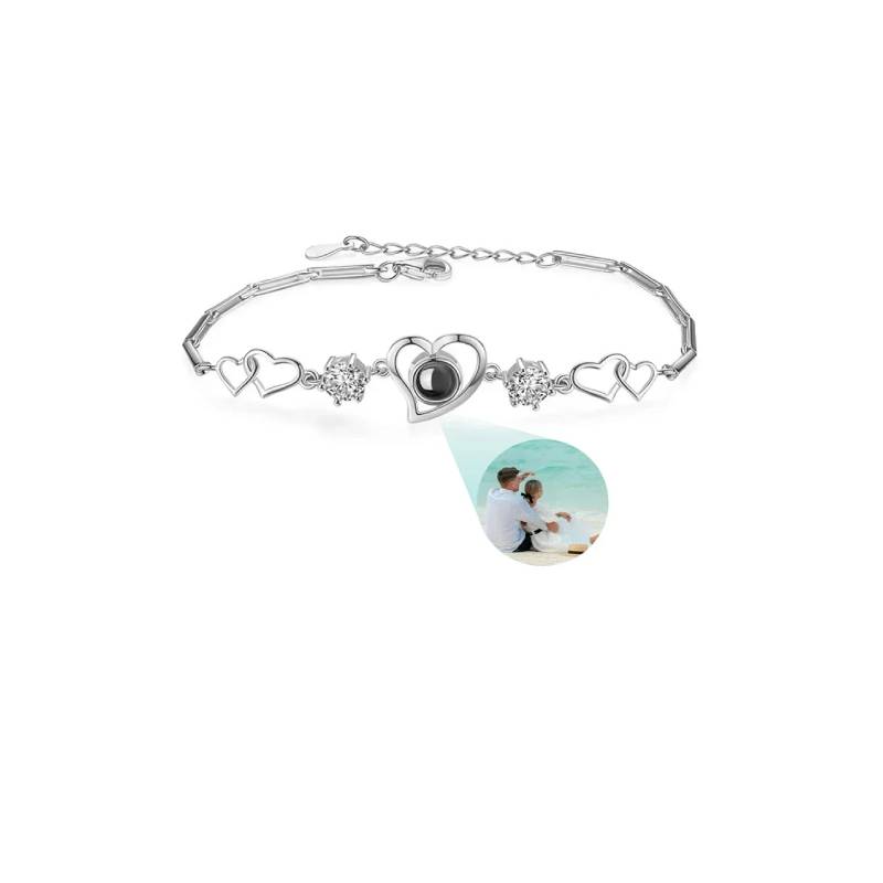 Silver bracelet with heart and heart-shaped charm on a white background