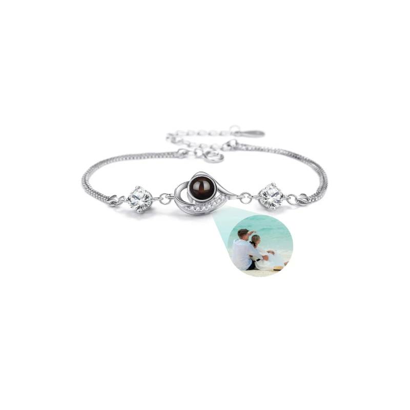 Silver bracelet with a teardrop-shaped photo charm on a white background