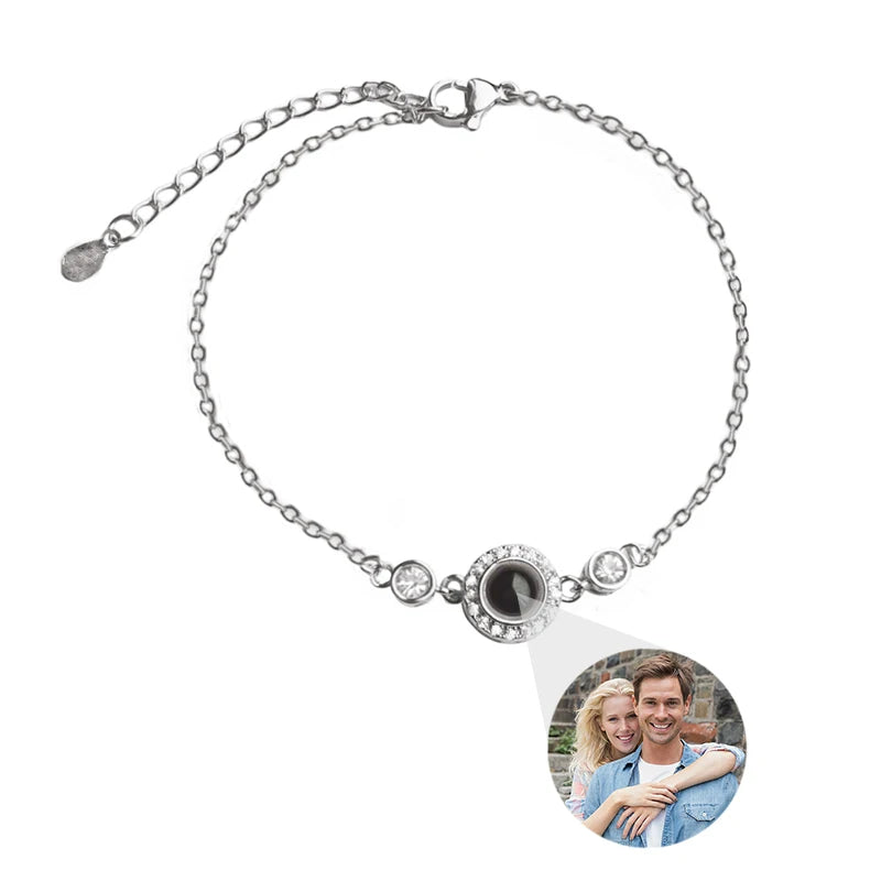 Silver bracelet with a round charm featuring a photo of a couple on a white background