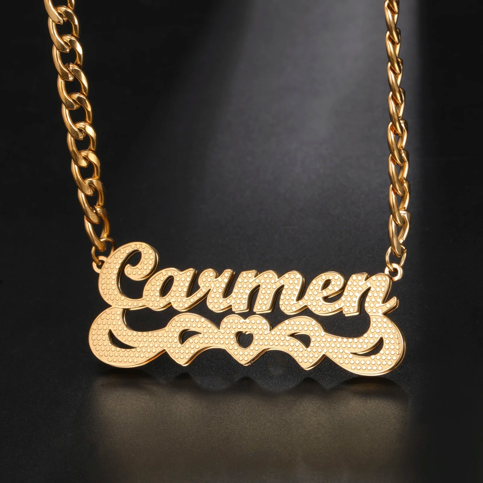 Gold necklace with 'Carmen' pendant on a dark background