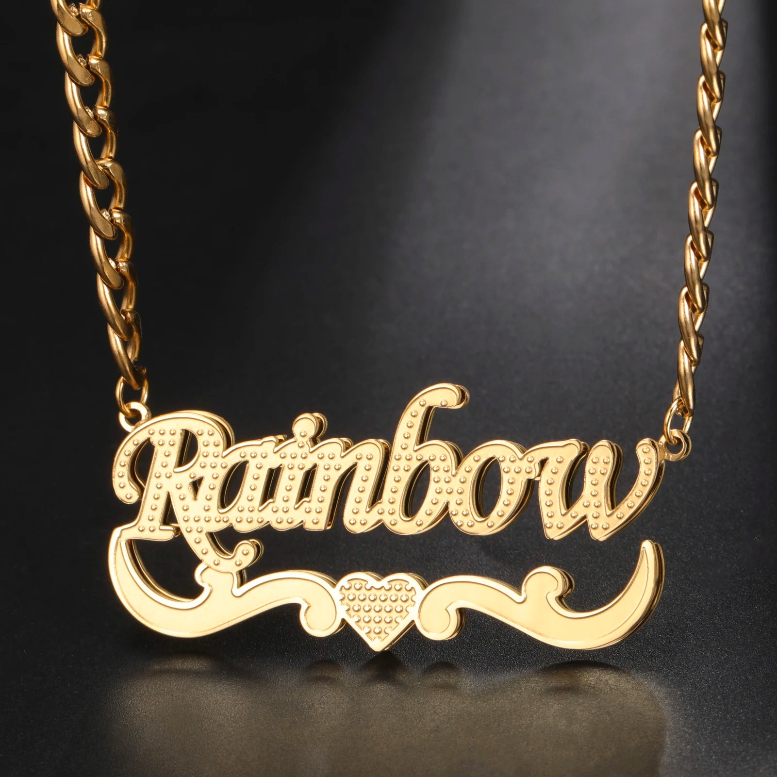 Gold necklace with 'Rainbow' pendant on a black background