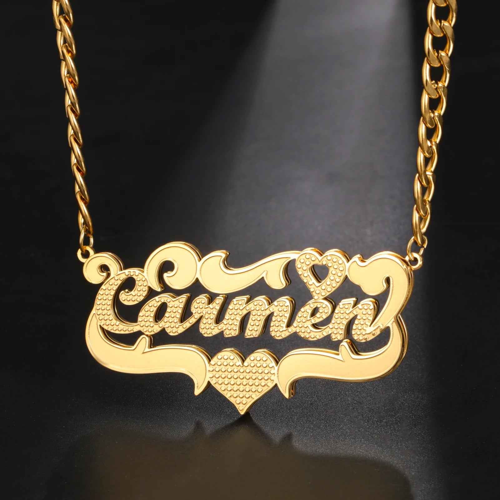 Gold necklace with 'Carmen' engraved on a dark background