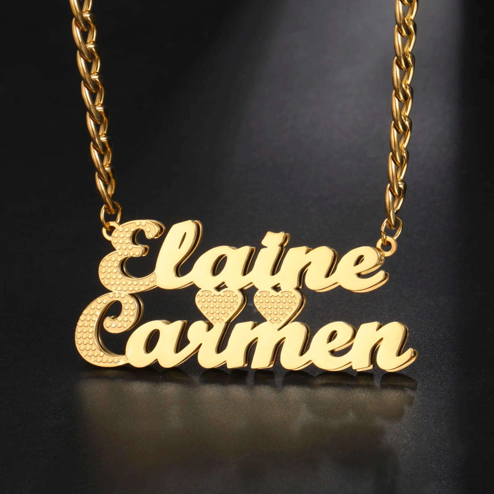 Gold necklace with 'Elaine Carmon' pendant on a dark background