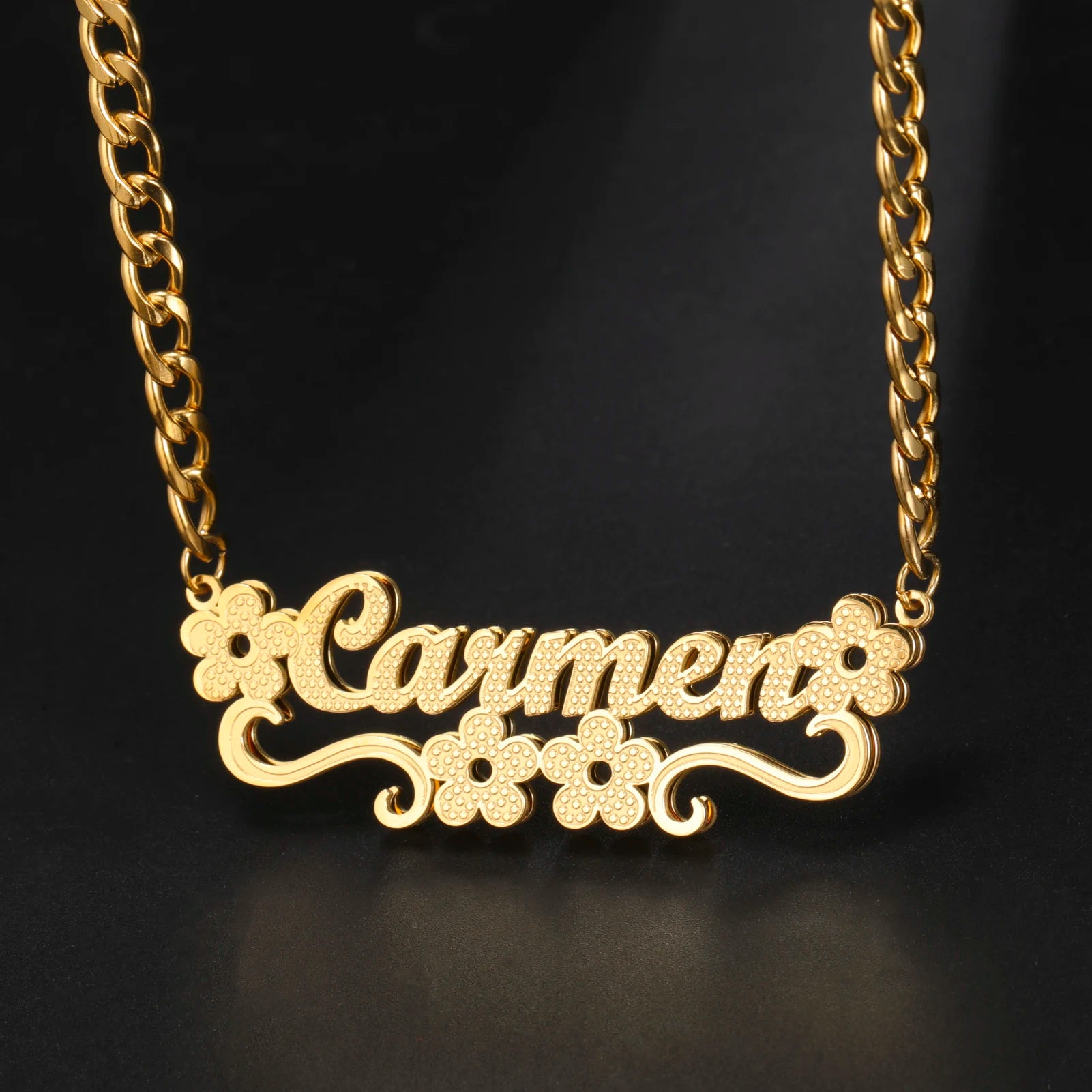 Gold necklace with 'Carmen' pendant on a black background