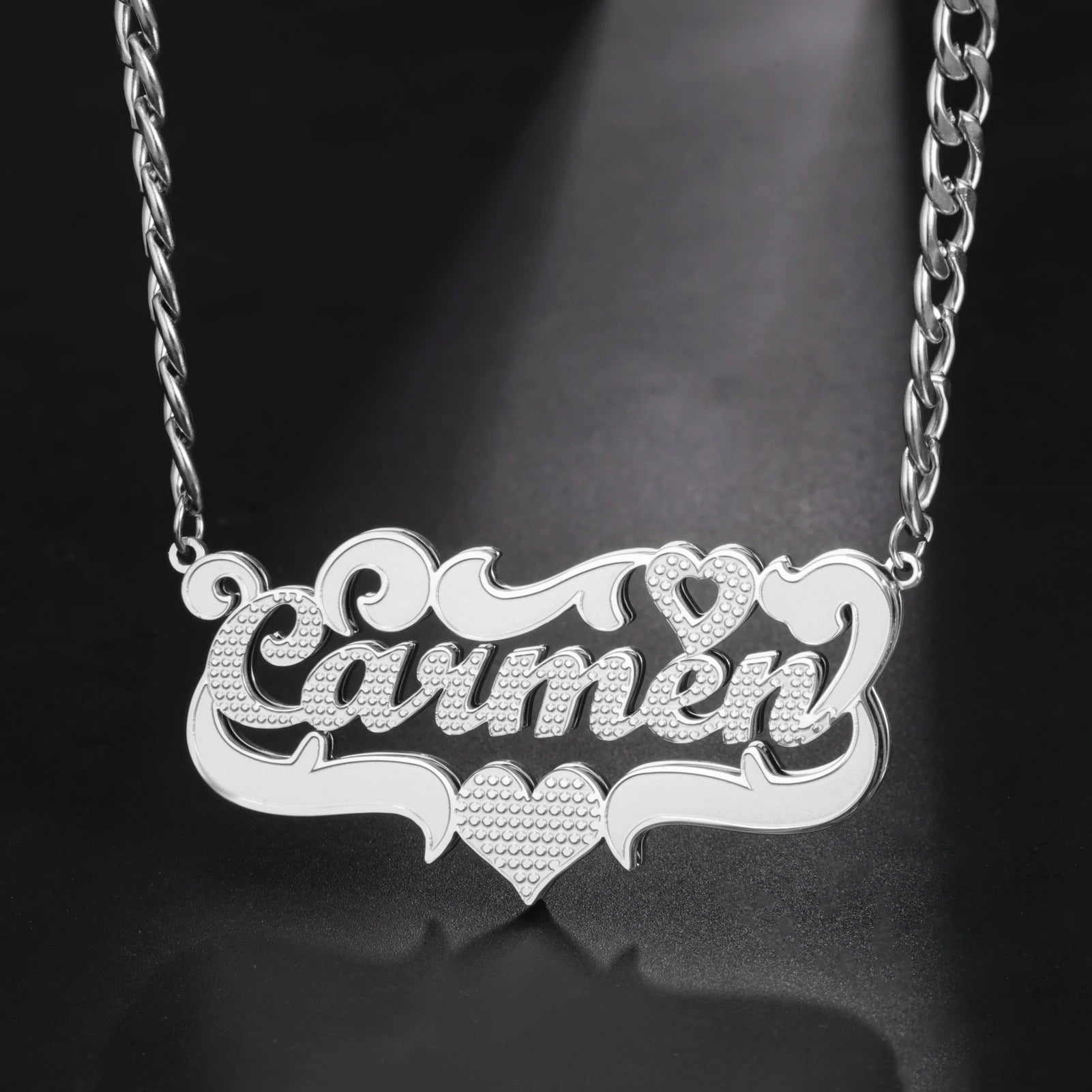 Silver necklace with 'Carmen' engraved on a dark background