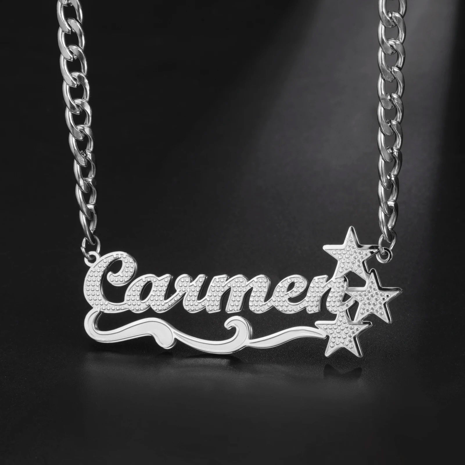 Silver necklace with 'Carmen' and star designs on a black background