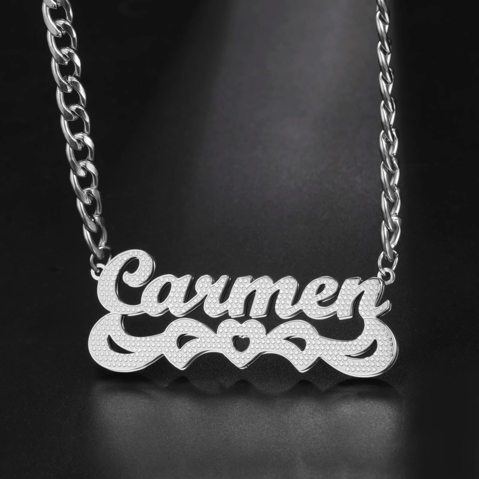 Silver necklace with 'Carmen' pendant on a black background