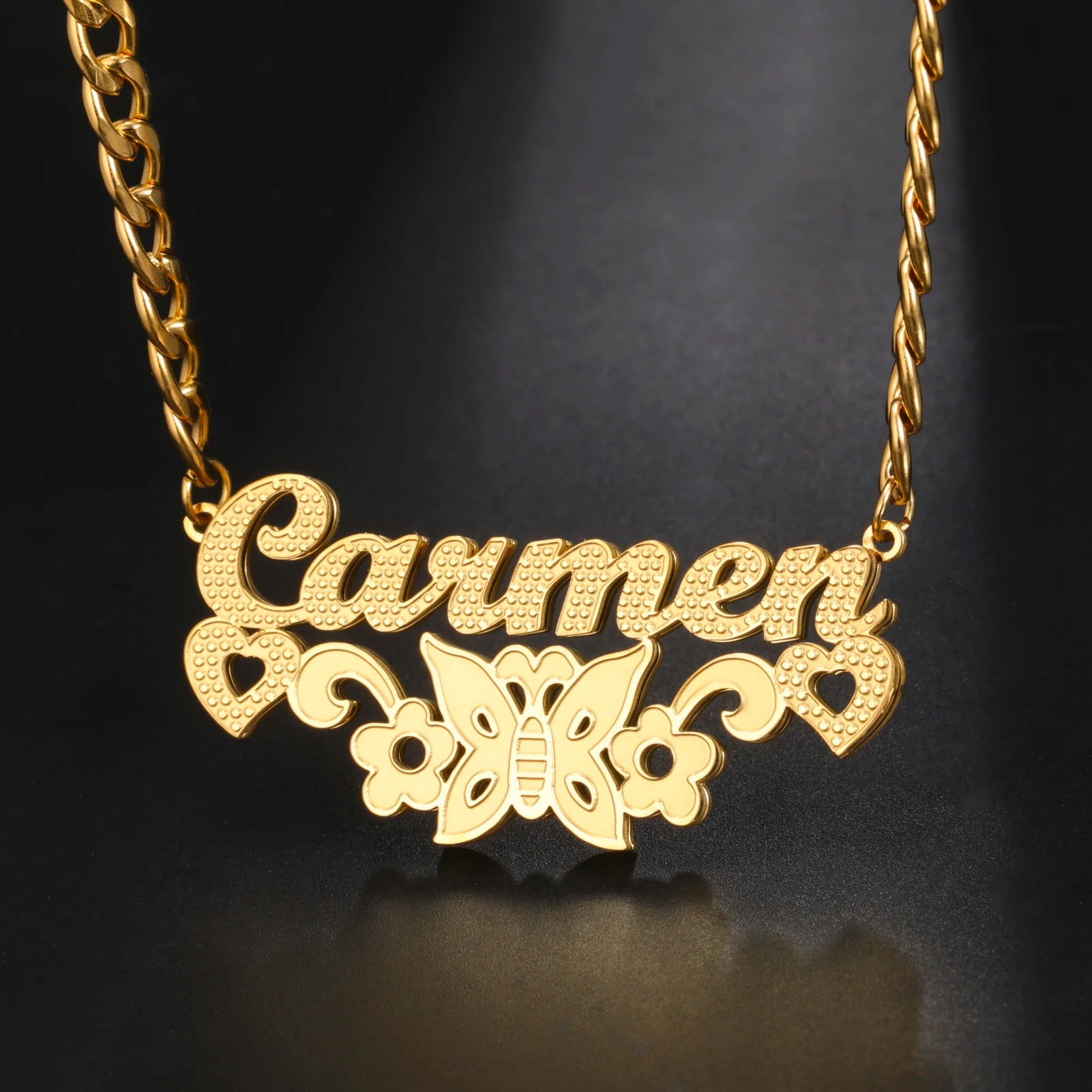 Gold necklace with 'Carmen' and butterfly design on a black background
