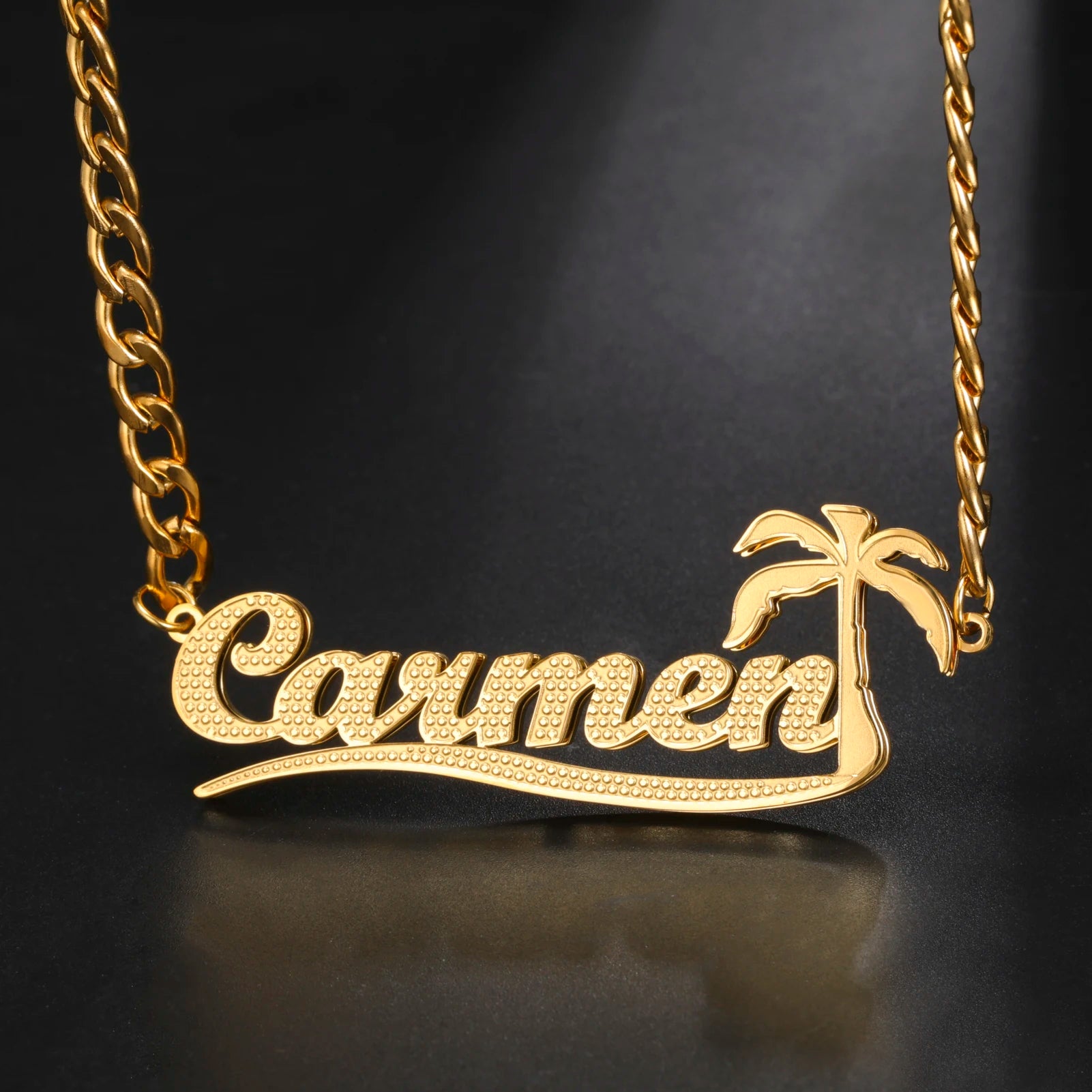 Gold necklace with 'Carmen' and palm tree design on a black background