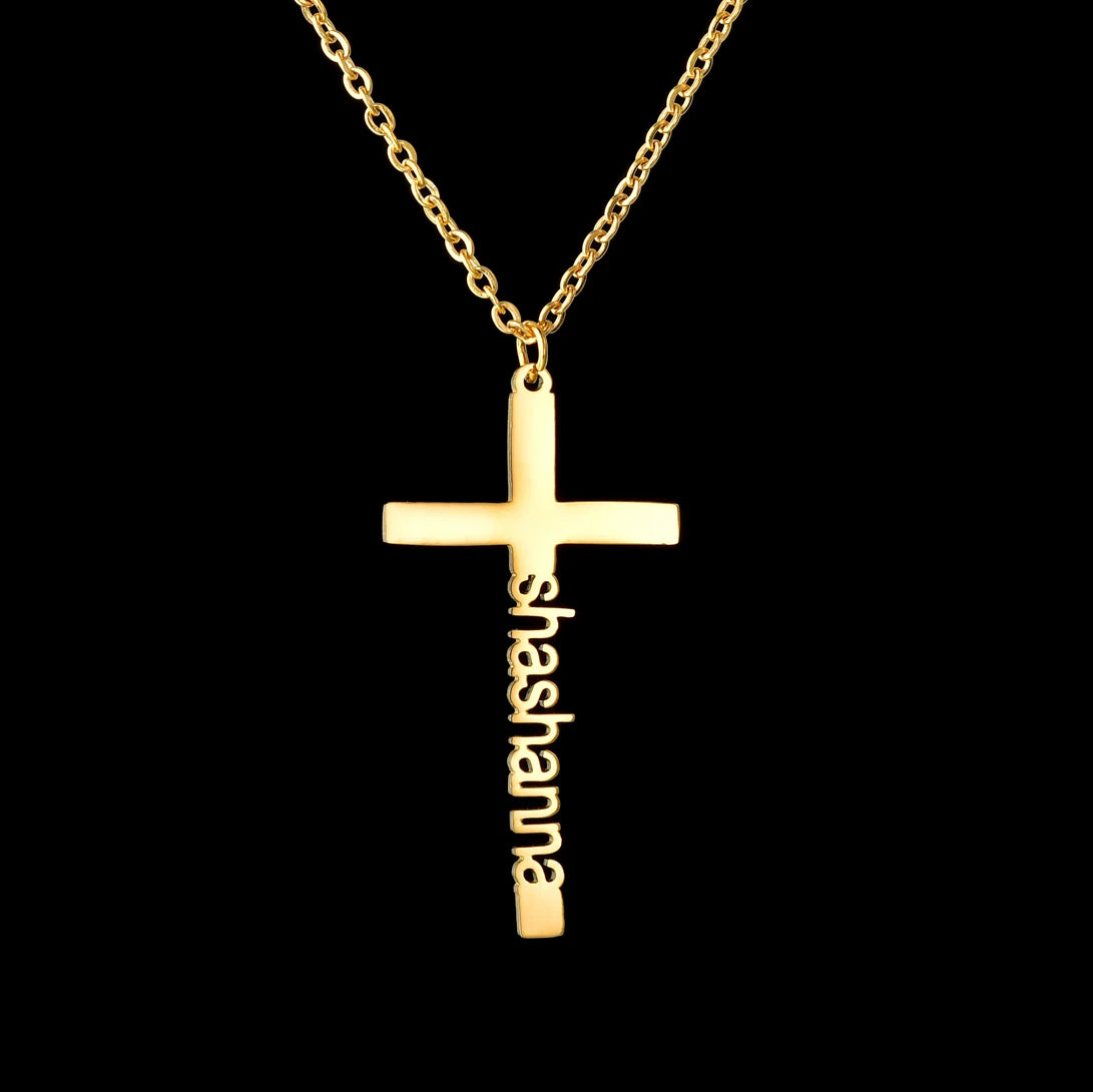Gold cross necklace with 'shashanna' engraving on a black background