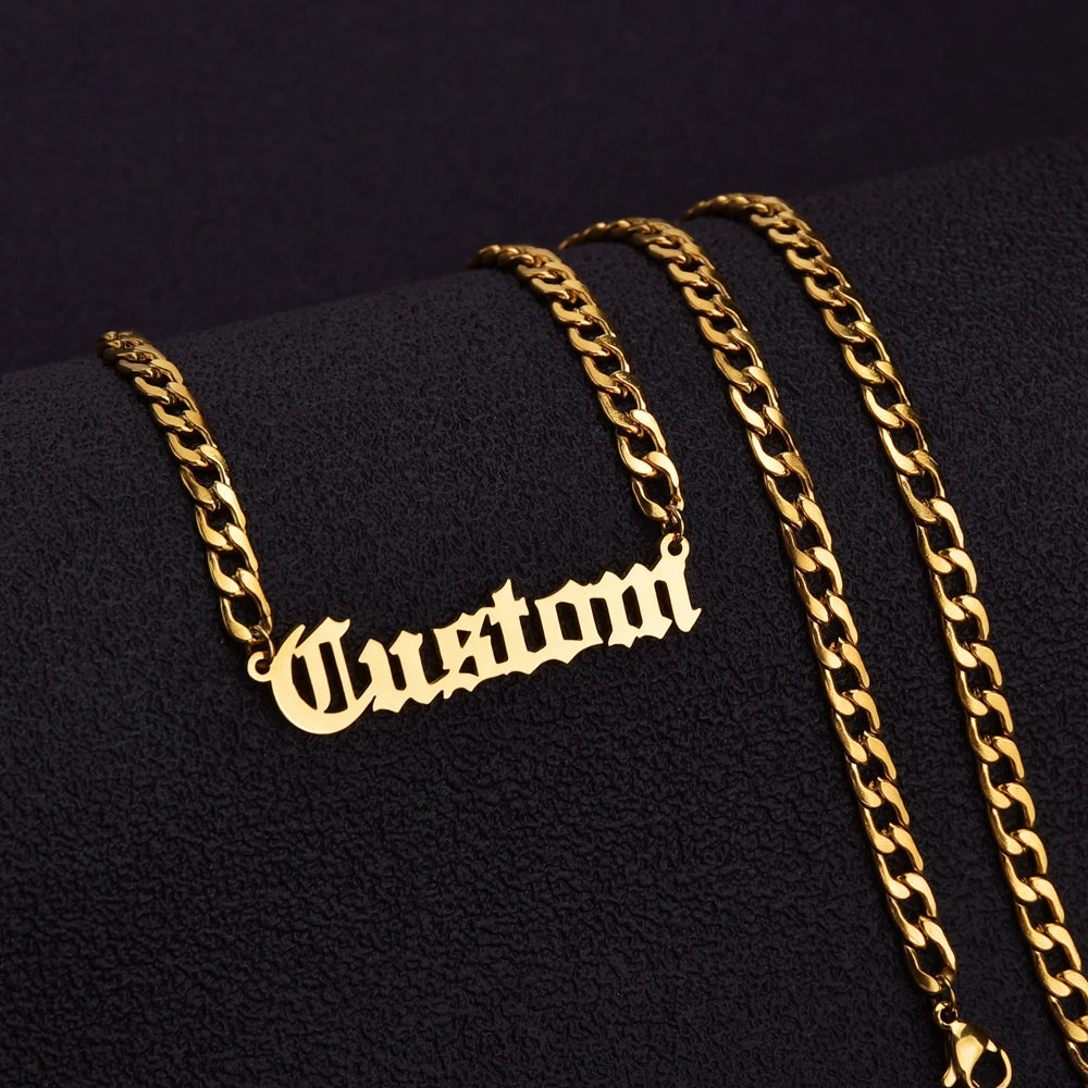 Gold chain necklace with 'Custom' pendant on a black background