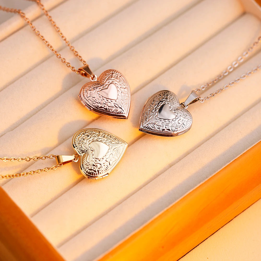 Three heart-shaped pendants on gold chains against a light wooden background