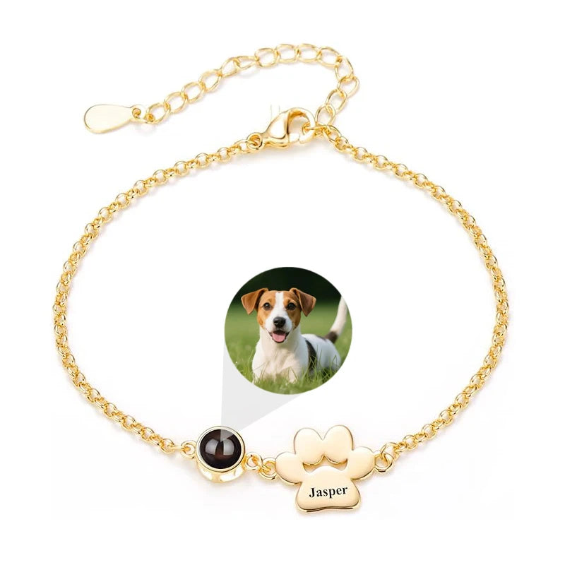 Gold bracelet with paw charm and photo of a dog on a white background