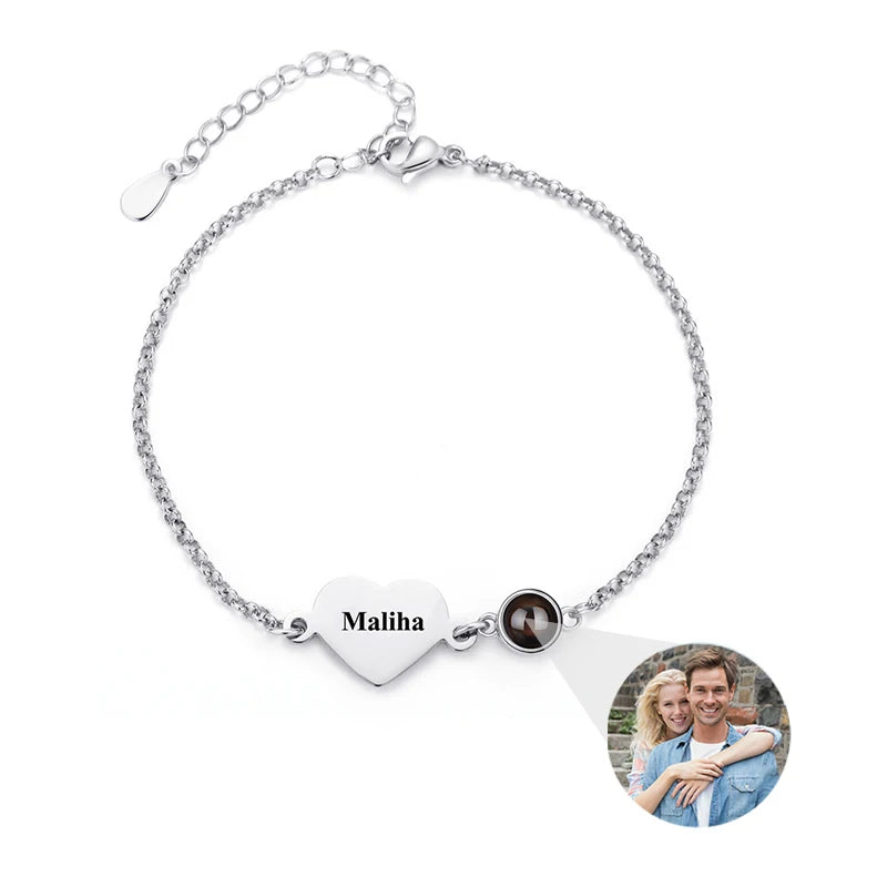 Silver bracelet with heart-shaped tag and photo charm on a white background