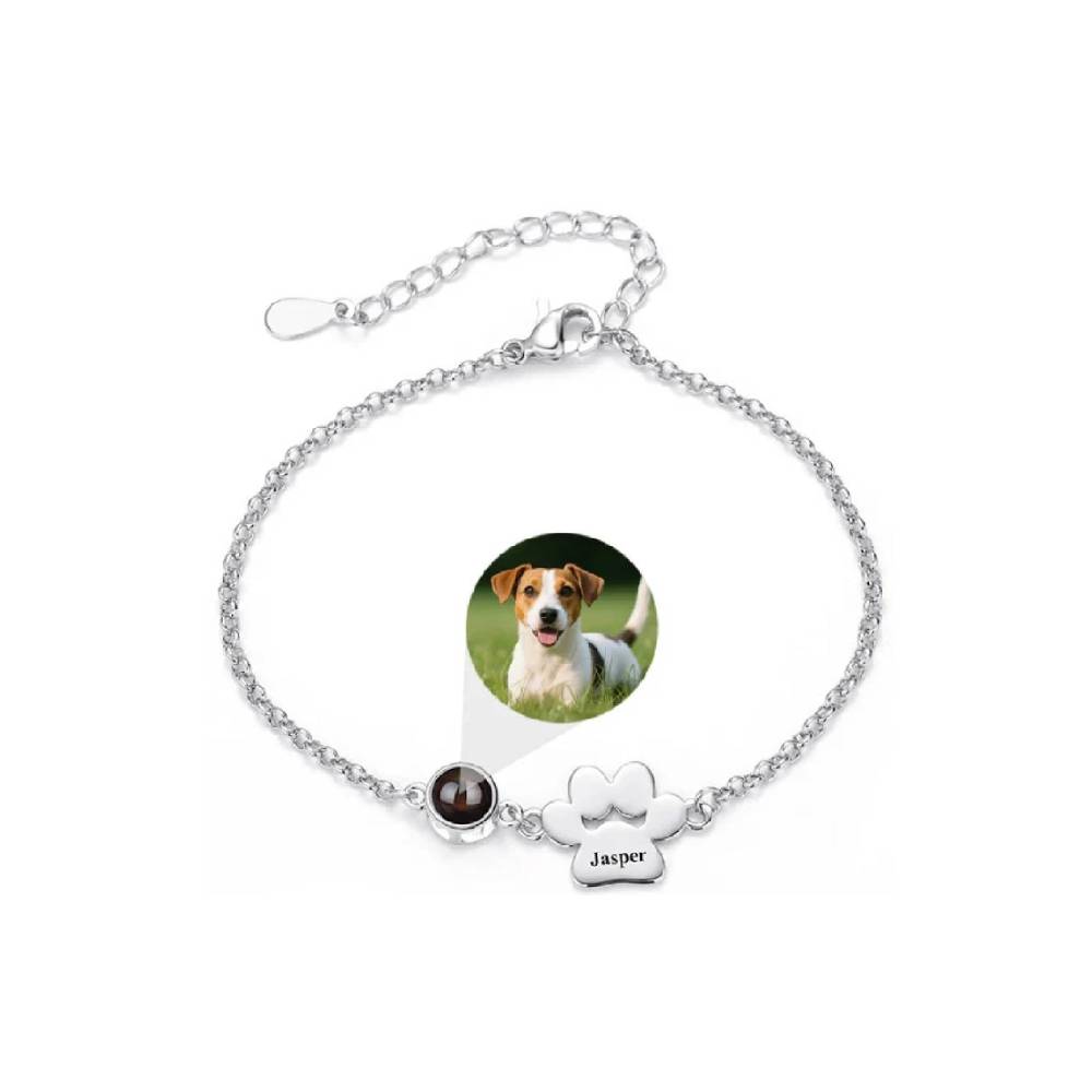 Silver bracelet with paw print charm and photo of a dog on a white background