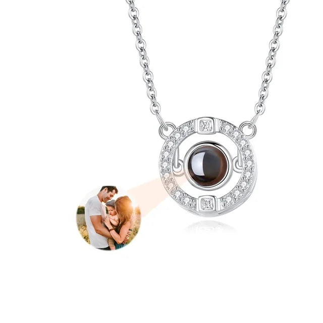 Necklace with a round pendant projecting an image of a couple on a white background