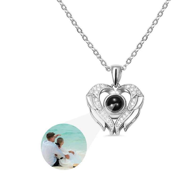Heart-shaped silver pendant with black gemstone on a white background