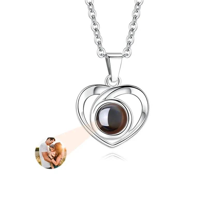 Heart-shaped silver pendant with a brown gemstone on a white background