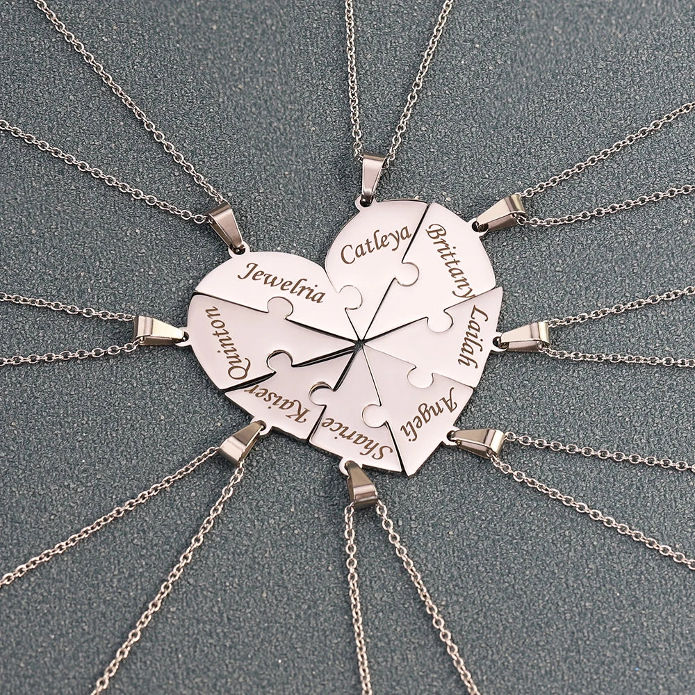 Heart-shaped puzzle piece necklace with engraved names on a gray background