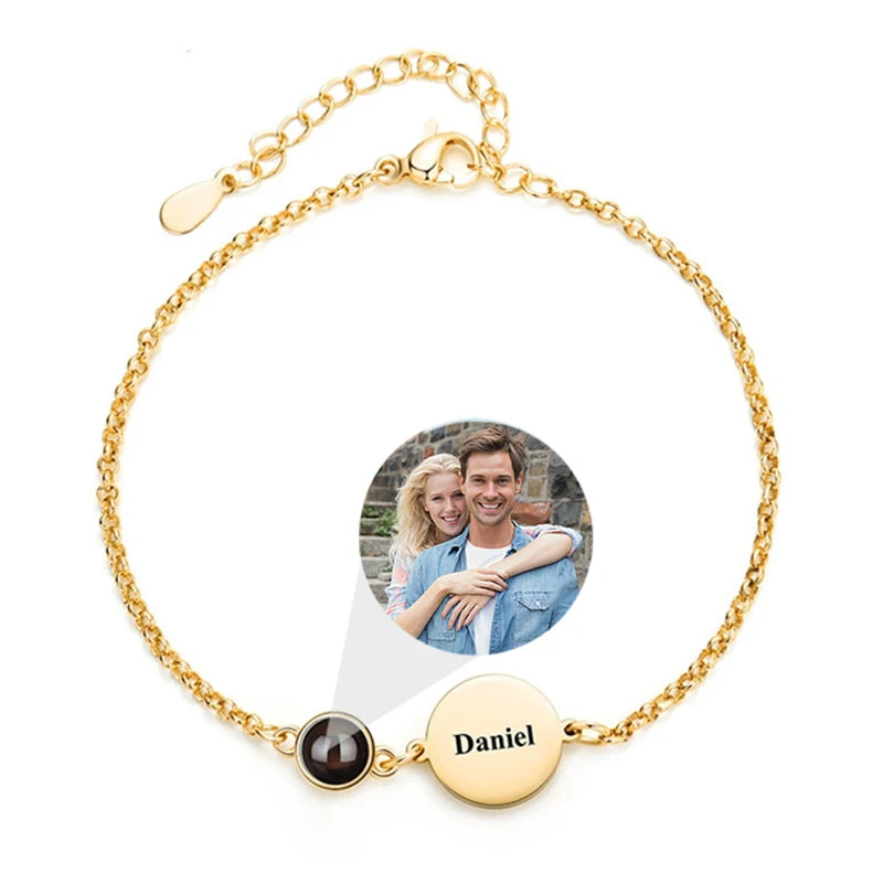Gold bracelet with a photo charm and engraved name on a white background