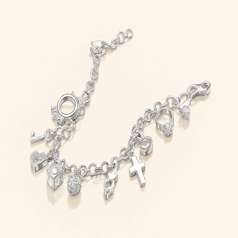 Silver charm bracelet with various charms on a light beige background