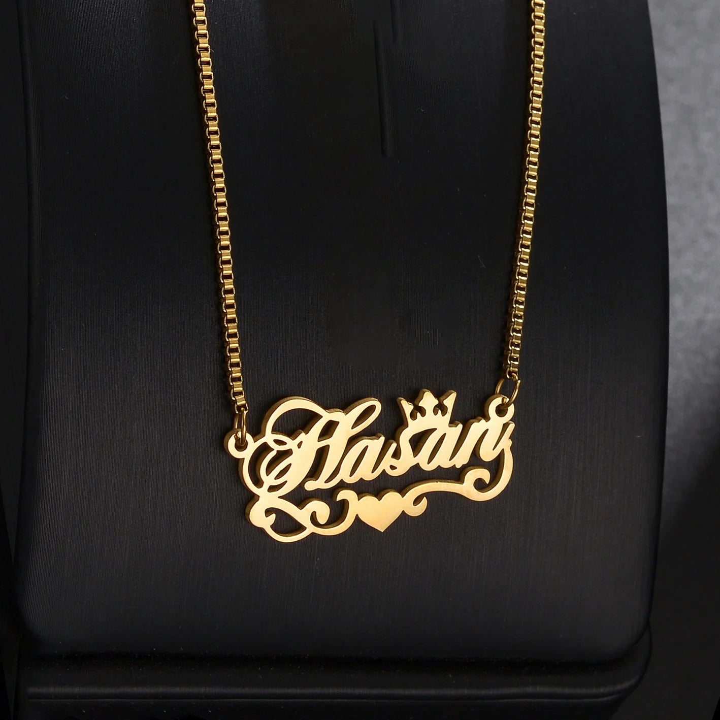 Gold necklace with 'Flasari' pendant on a black background